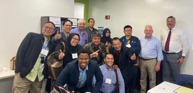 Consultant networking with attendees after a speaking event.